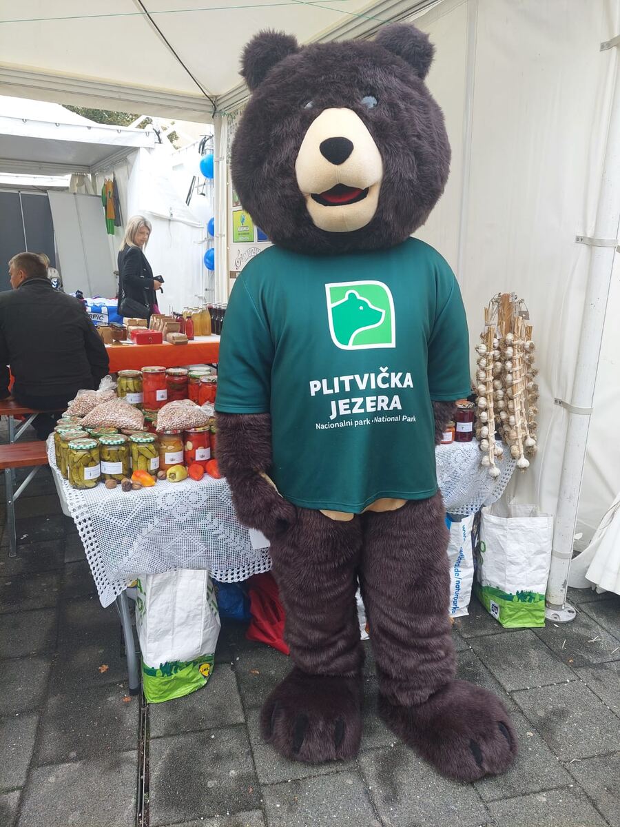 Maskota medvjed Plitvička jezera ispred štanda